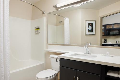 La salle de bains est pourvue d'un lavabo, de toilettes et d'un miroir. dans l'établissement Candlewood Suites Charleston-Northwoods, an IHG Hotel, à Charleston