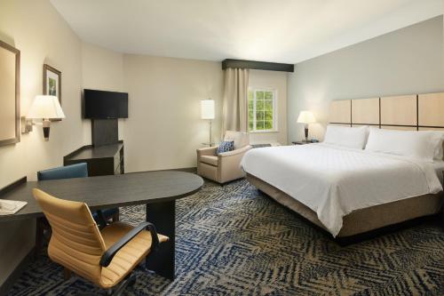 a hotel room with a bed and a desk and chair at Candlewood Suites Charleston-Northwoods, an IHG Hotel in Charleston