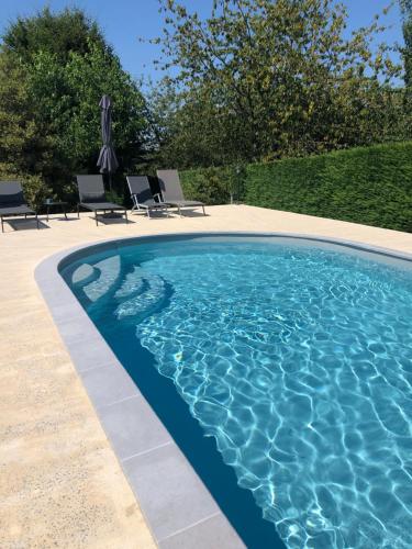 une piscine avec de l'eau bleue dans une cour dans l'établissement Cottage Philmaries, à Coudert