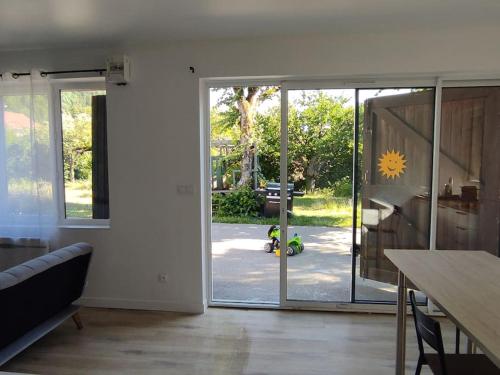 a living room with a sliding glass door to a yard at Studio entre lac de Monteynard et Gresse-en-Vercors in Monestier-de-Clermont