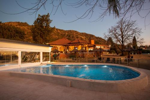 ヴィラ・カルロス・パスにあるPinares del Cerro Resort & Suitesの家の前の大型スイミングプール