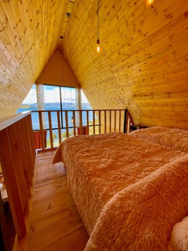 a bedroom with two beds in a wooden room at La Puerta Del Lago ECOPARQUE in Tota