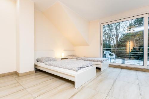 a bedroom with two beds and a large window at Komfort Design Wohnung Köln in Cologne