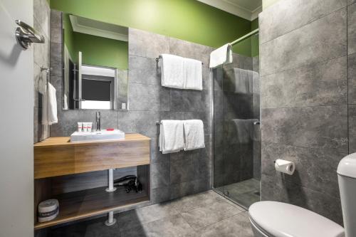 ein Bad mit einem Waschbecken und einer Dusche in der Unterkunft Nightcap at Pritchards Hotel in Mount Pritchard