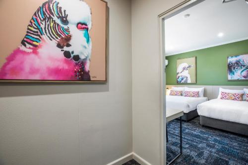 a room with a mirror and a bed and a bed and a mirror at Nightcap at Pritchards Hotel in Mount Pritchard