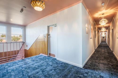 an empty hallway with a door and a staircase at Nightcap at Pritchards Hotel in Mount Pritchard