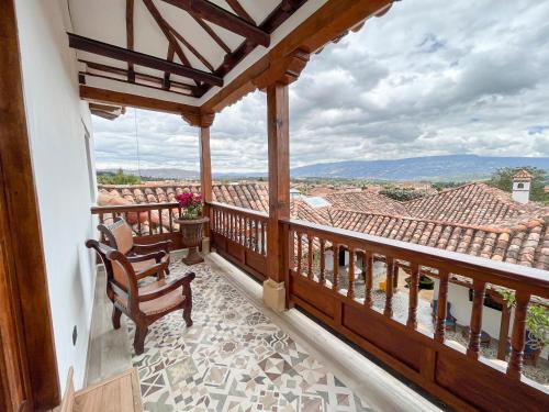 a balcony with two chairs and a view of a roof at Hotel Boutique El Carmel in Villa de Leyva