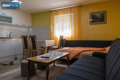 een woonkamer met een bed en een tafel bij Apartman Raj Macevine in Bajina Bašta