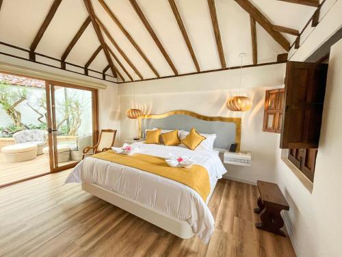 ein Schlafzimmer mit einem Bett und einem großen Fenster in der Unterkunft Hotel Boutique El Carmel in Villa de Leyva