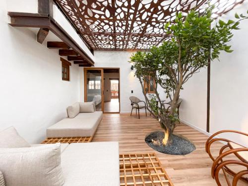 a living room with a couch and a tree at Hotel Boutique El Carmel in Villa de Leyva