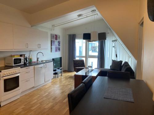 kuchnia i salon z kanapą i stołem w obiekcie Parken Terrasse Apartment Hotel w mieście Kopervik