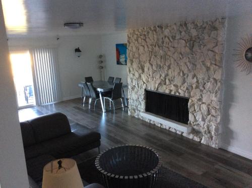 a living room with a stone fireplace and a table at 5 bedroom 3 bath home near universal in Sherman Oaks