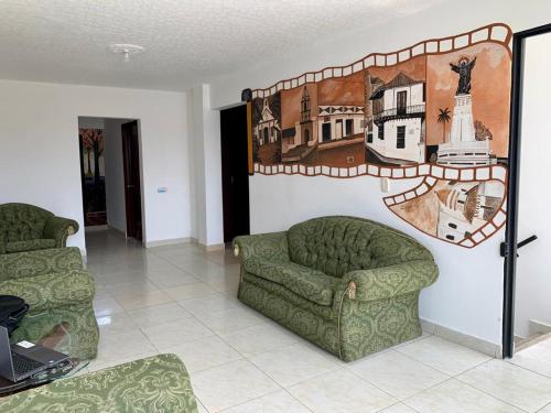 a living room with two chairs and a couch at Hotel San Cayetano in Ocaña