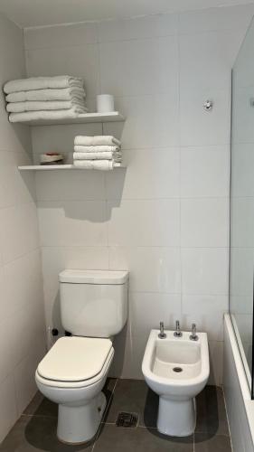 a white bathroom with a toilet and a sink at Administración MAIPU PB B Depto Premium in Tandil