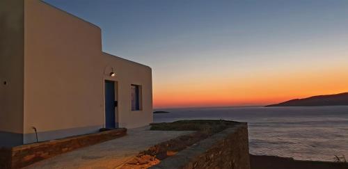 a white building with the sunset in the background at St George Village in Batsi
