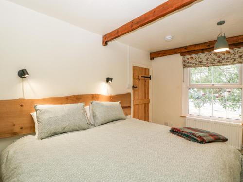 Tempat tidur dalam kamar di Tinmans Cottage