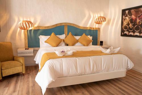 a bedroom with a large bed with a blue headboard at Hotel Boutique El Carmel in Villa de Leyva