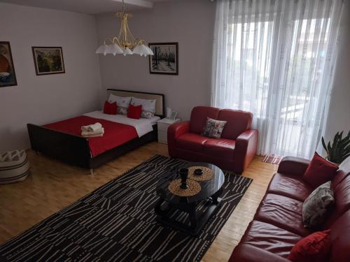 een woonkamer met een bank en een bed bij Apartman Sabah in Novi Pazar