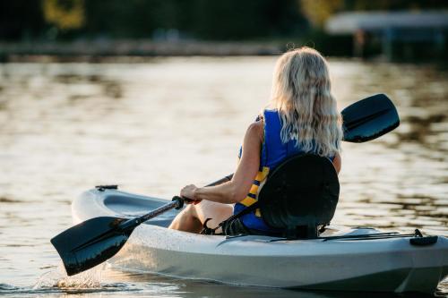 a woman sitting on a kayak in the water at Aloha Beach Resort in Wisconsin Dells