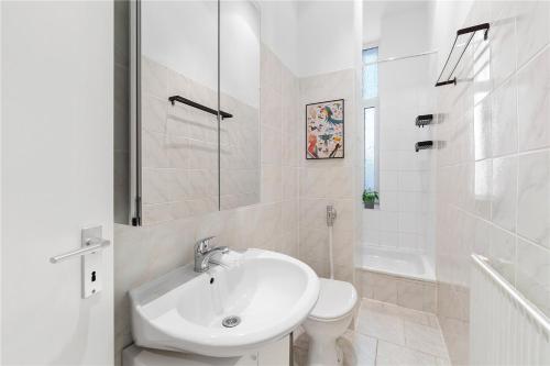 een witte badkamer met een wastafel en een toilet bij Holiday 33 Apartment I Mitte in Berlijn