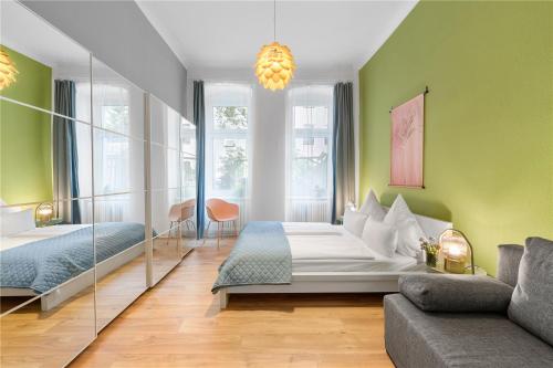 een slaapkamer met 2 bedden en een bank in een kamer bij Holiday 33 Apartment I Mitte in Berlijn