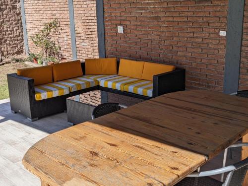 two tables and a couch on a patio at Don Trujo 2 - parque y pileta in Mendoza