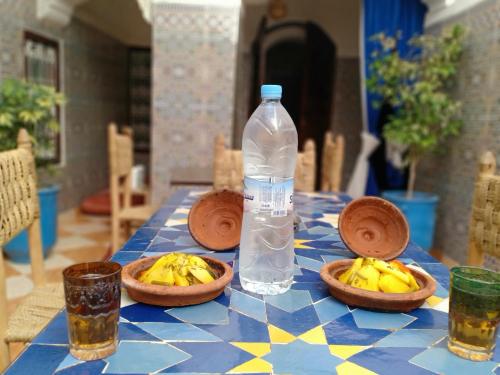 - une bouteille d'eau et des bols de bananes sur une table dans l'établissement Riad White House, à Marrakech