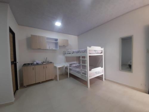 Dieses weiße Zimmer verfügt über ein Etagenbett und eine Küche. in der Unterkunft ALOJAMIENTO El Lago in San Andrés