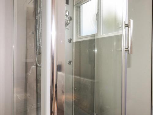 a shower with a glass door and a window at Atlantic Apartment in Bude