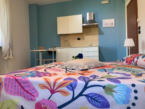 a bedroom with a bed with a colorful blanket at Mini-Appartamenti, Camere Lanterna Blu in Mombello Monferrato