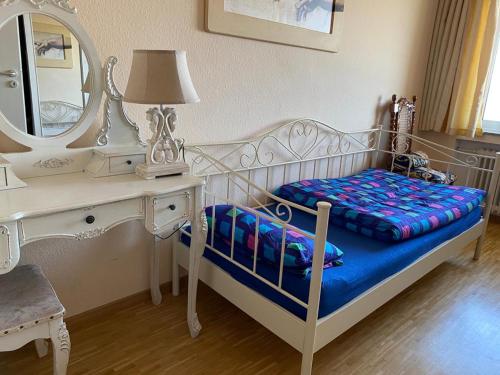 a bedroom with a bed with a dressing table and a mirror at Blick über Bonn ins Siebengebirge in Bonn