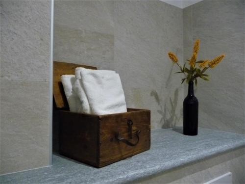 a bathroom with a box of towels and a vase of flowers at Casa Patrito - Appartamento Barolo in Barolo