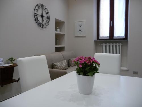 uma mesa branca com um vaso de flores em Casa Patrito - Appartamento Barolo em Barolo