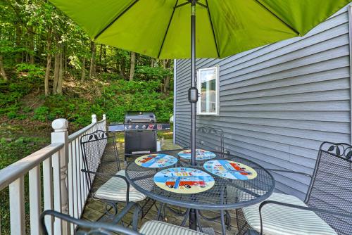 a patio with a table and chairs with an umbrella at Lakefront Newaygo Home - Private Dock, Kayaks in Newaygo