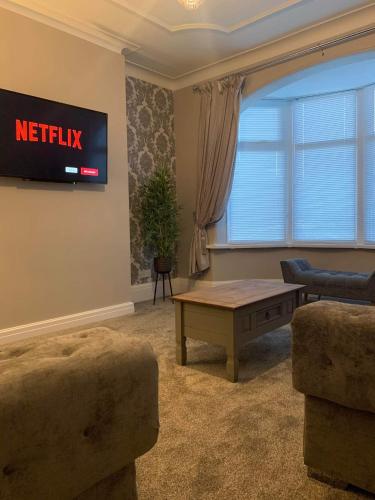 a living room with a tv and a coffee table at Pleasure Beach View in Blackpool