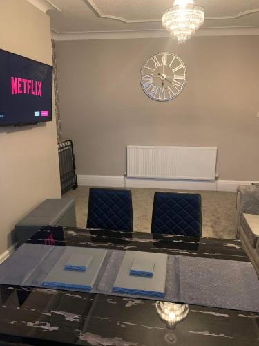 a meeting room with a table and chairs and a clock at Pleasure Beach View in Blackpool