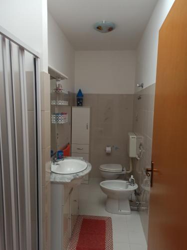 La salle de bains est pourvue de 2 lavabos et de toilettes. dans l'établissement Casa Gialla, à Torre Pali