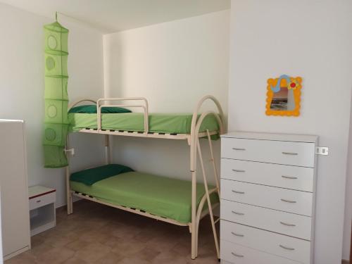 - une chambre avec des lits superposés et une commode dans l'établissement Casa Gialla, à Torre Pali