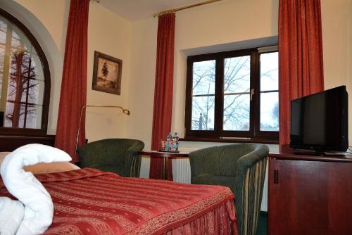 a hotel room with a bed and a flat screen tv at Willa Victor in Jastrzębia Góra