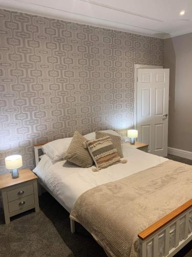 a bedroom with a bed with two tables and two lamps at Pleasure Beach View in Blackpool