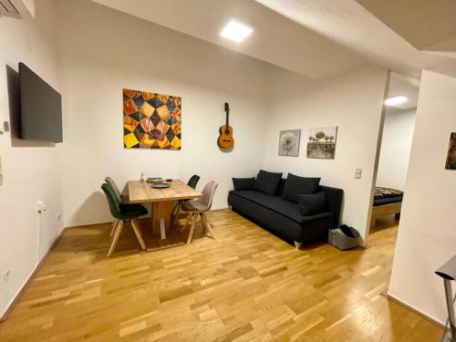 uma sala de estar com um sofá e uma mesa em Ruhiges Dachgeschoß CityApartment im Zentrum Wiens em Viena