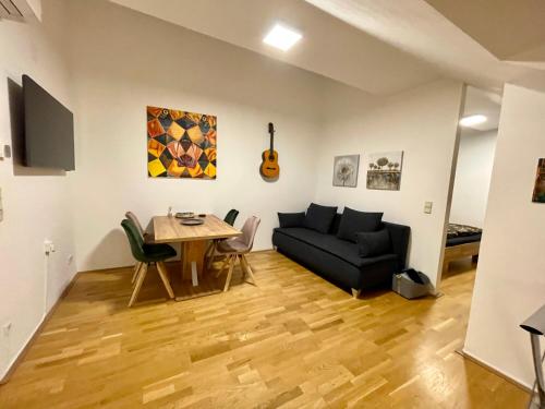 ein Wohnzimmer mit einem Sofa und einem Tisch in der Unterkunft Ruhiges Dachgeschoß CityApartment im Zentrum Wiens in Wien
