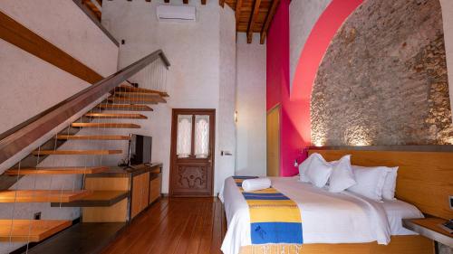 een slaapkamer met een bed en een trap bij Hotel Boutique Casona de la China Poblana - Adults Only in Puebla