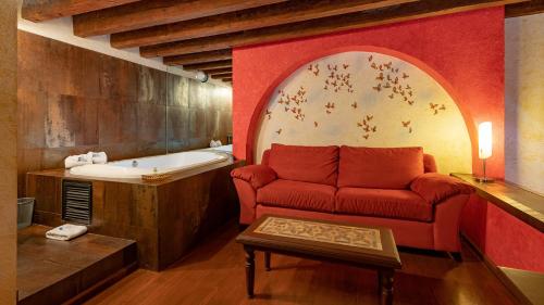 een woonkamer met een bank en een bad bij Hotel Boutique Casona de la China Poblana - Adults Only in Puebla
