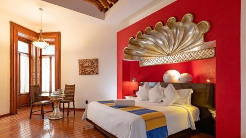 a hotel room with a bed and a red wall at Hotel Boutique Casona de la China Poblana - Adults Only in Puebla
