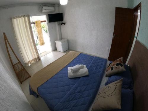 a small bedroom with a blue bed and a window at Pousada Serra&Mar Angra dos reis in Angra dos Reis