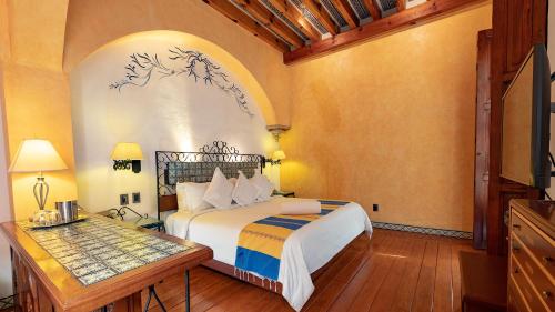 a bedroom with a bed and a table in a room at Hotel Boutique Casona de la China Poblana - Adults Only in Puebla