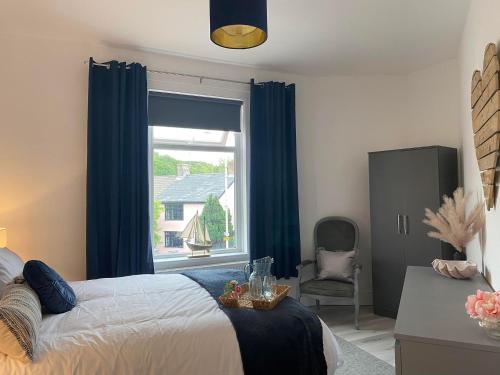 a bedroom with a bed and a large window at The Retreats 2 Kenfig Hill Pet Friendly 2 Bedroom Flat with King Size bed twin beds and sofa bed sleeps up to 5 people in Kenfig Hill