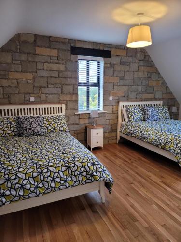 um quarto com 2 camas e uma parede de tijolos em Waterdale Lodge em Galway