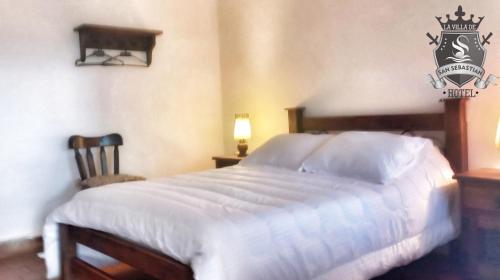 a bedroom with a large white bed in a room at La Villa de San Sebastian Hotel in Villa de Leyva